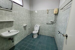 A bathroom with a toilet, sink, and hand dryer. - Rung Rueng Resort (Chonnabot)