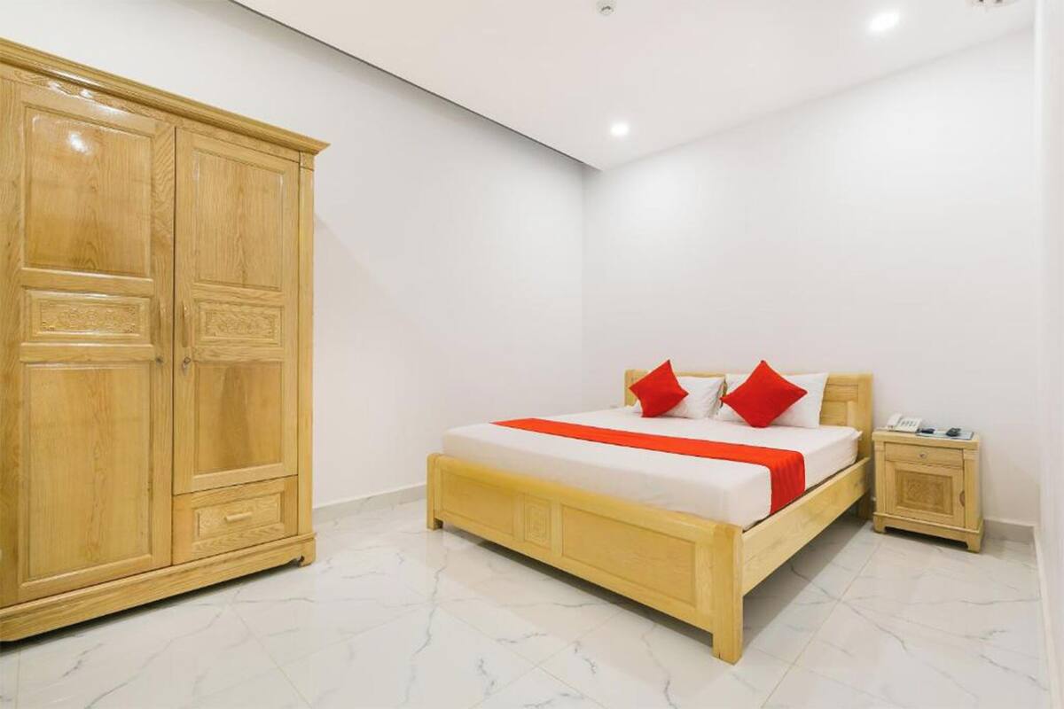 A bedroom with a wooden bed, a nightstand, and a wardrobe.