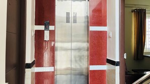 An elevator with a metallic finish and red-tiled walls. - Marvel Comforts Near Fortis Hospital, Bannerghatta Road (Bengaluru)