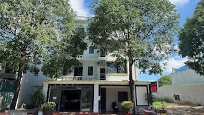 A hotel entrance with a covered walkway, potted plants, and a sign indicating the hotel's name. - Thanh Hang Hotel (Ho Chi Minh City)