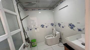 A bathroom with a toilet, sink, and shower.