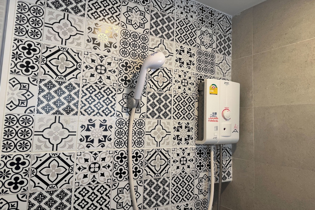 A bathroom with patterned tiles and a built-in shower unit.