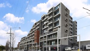 A multi-story residential building with balconies, a mix of window styles, and a modern architectural design. - Coburg Loft – 270° Views Skyline Escape (Coburg)