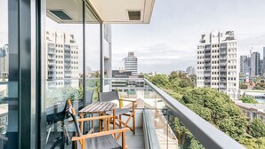 Ein Balkon mit Tisch und Stühlen und Blick auf die Stadt.