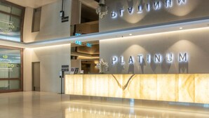 A Platinum hotel reception area with a marble counter and a sign above it.