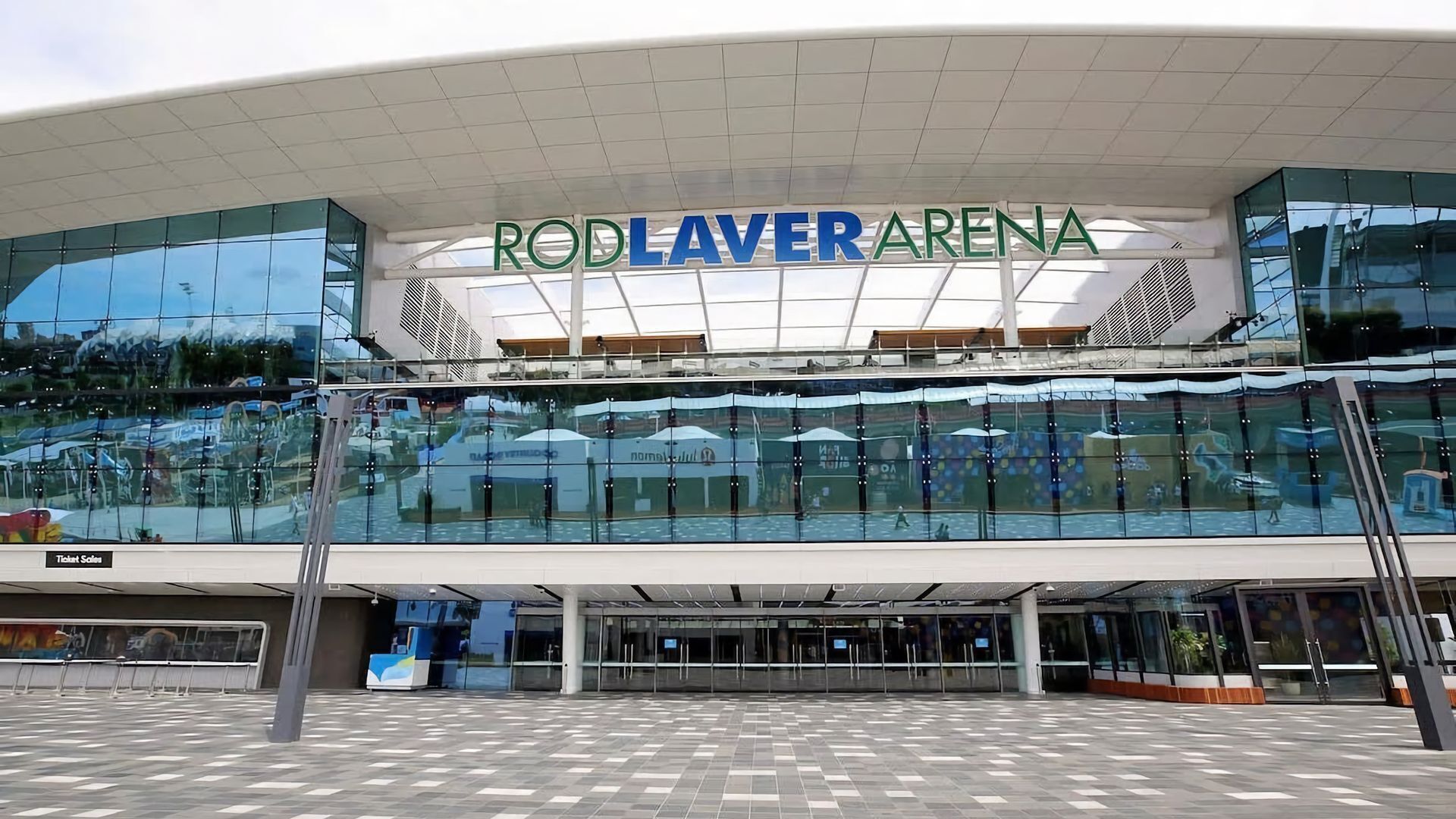 The exterior of the Rod Laver Arena with a glass facade and a modern architectural design.