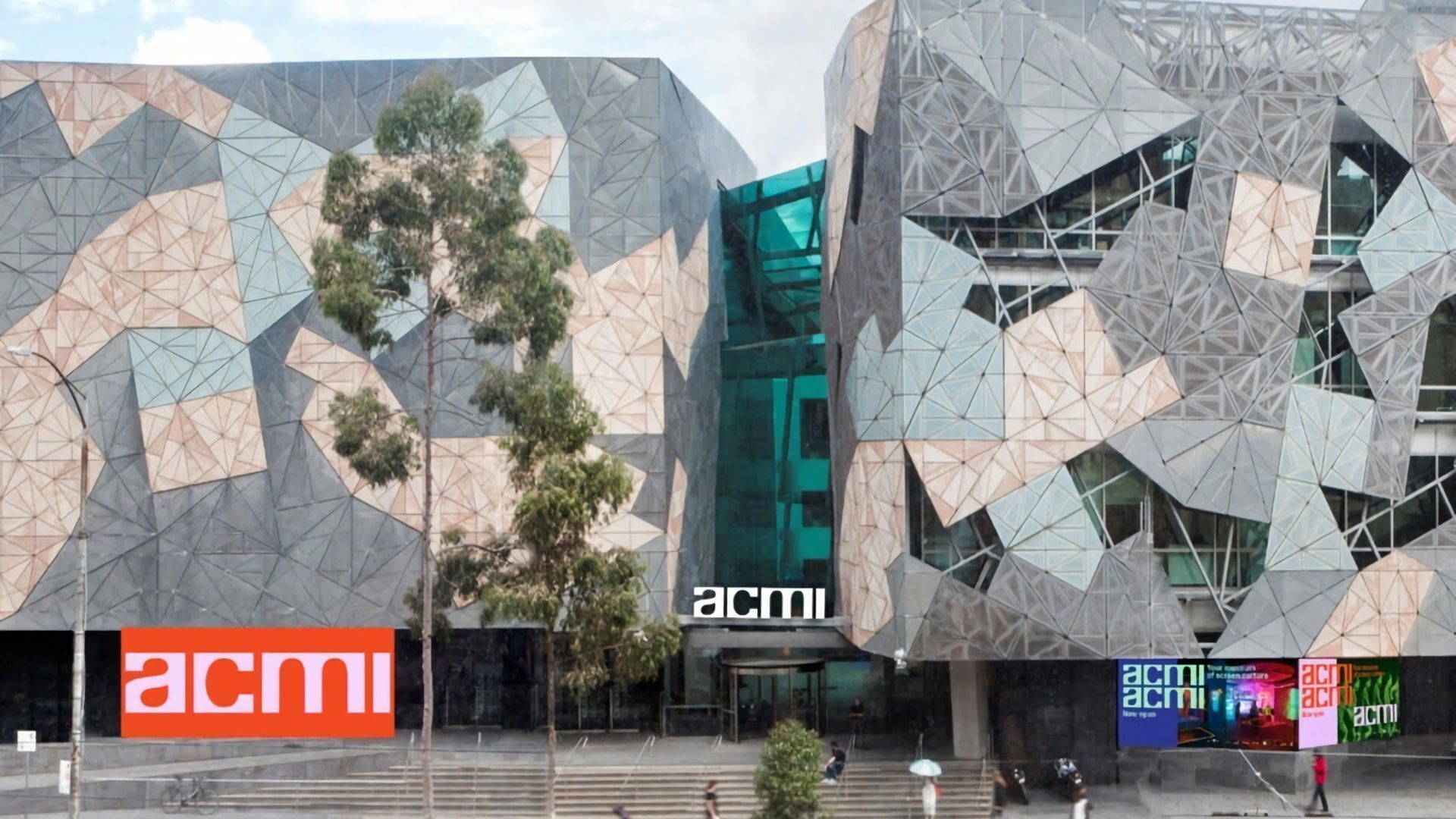 Ein modernes Gebäude mit geometrischen Mustern und dem 'acmi'-Logo.