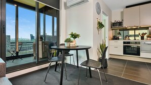 A modern kitchen with a dining area, large windows, and a view of a stadium.