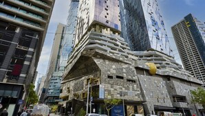 A modern building with a unique architectural design, featuring a prominent curved facade and a large golden sculpture. - Manhattan West Side 57 (Melbourne)