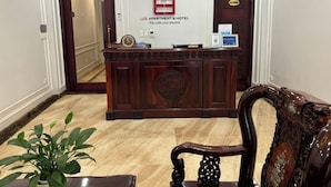 A reception desk with a sign reading "LEE APARTMENT & HOTEL We care your dreams" in a hotel lobby. - Lee Apartment & Hotel (Hai Phong)