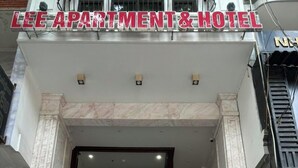 The entrance of Lee Apartment & Hotel with a glass door, a visible staircase, and a potted plant outside. - Lee Apartment & Hotel (Hai Phong)