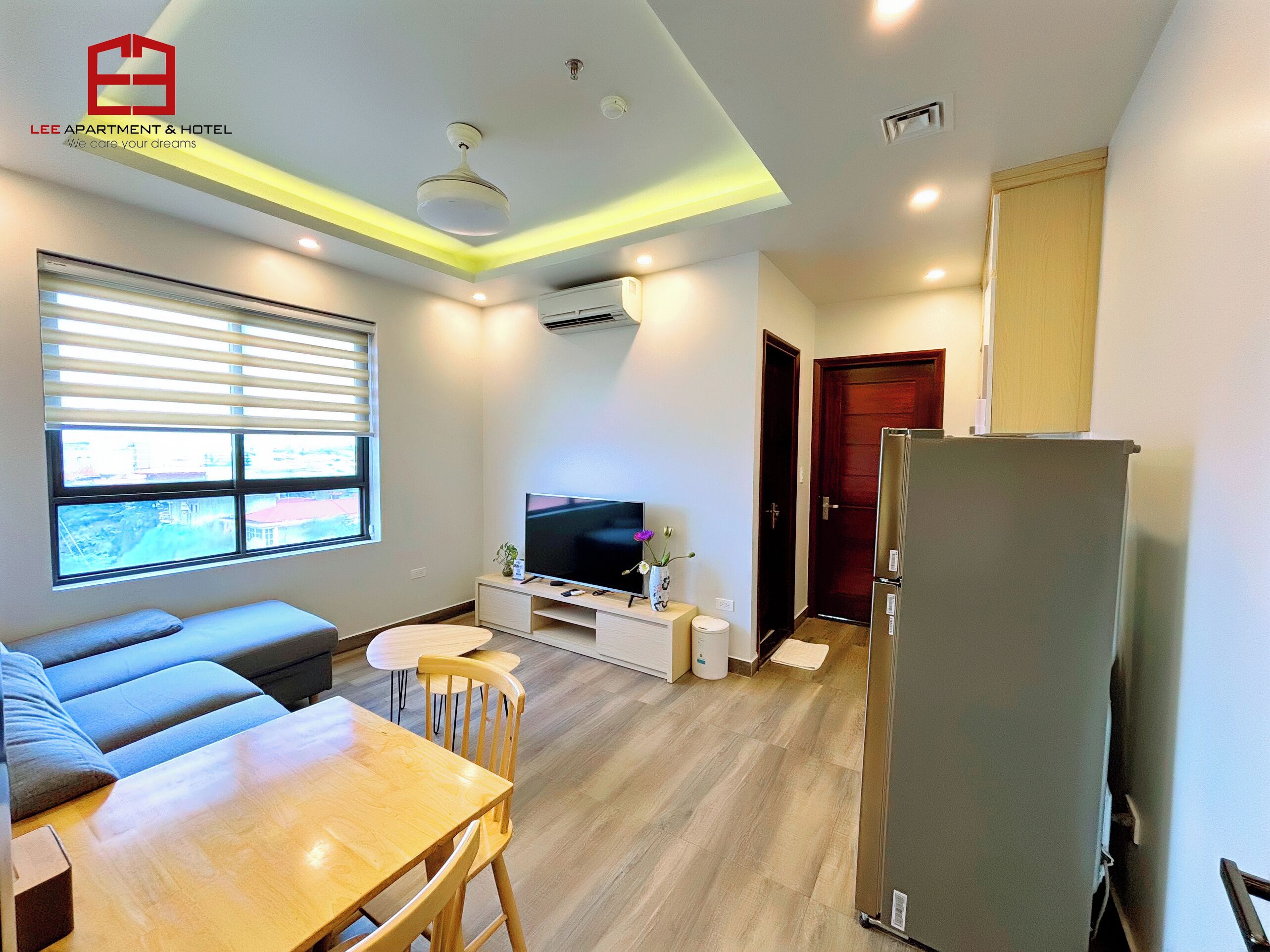 A modern living room with a sofa, a TV, and a dining table.