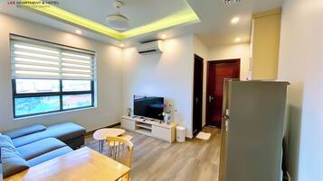 A modern living room with a sofa, a TV, and a dining table.