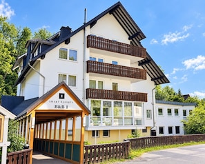 A multi-story hotel with balconies and a sign indicating 'SMART RESORTS B&B 1'. - Comfortable and versatile room -perfect for relaxation, work and exchange (Winterberg)