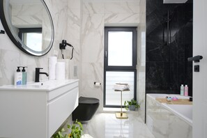 A modern bathroom with a black toilet, white vanity, and a black shower. - The Clock (Voluntari)