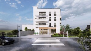 Ein modernes, mehrstöckiges Gebäude mit ebener Fassade, großen Fenstern und einem zentralen Eingang.