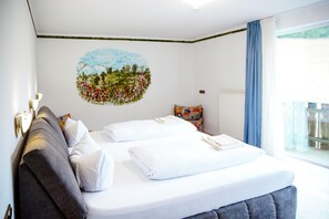 A hotel room with a bed, a wall mural, a window with curtains, and a view of the outside. - A comfortable and versatile room—perfect for relaxation, work, and socializing (Winterberg)