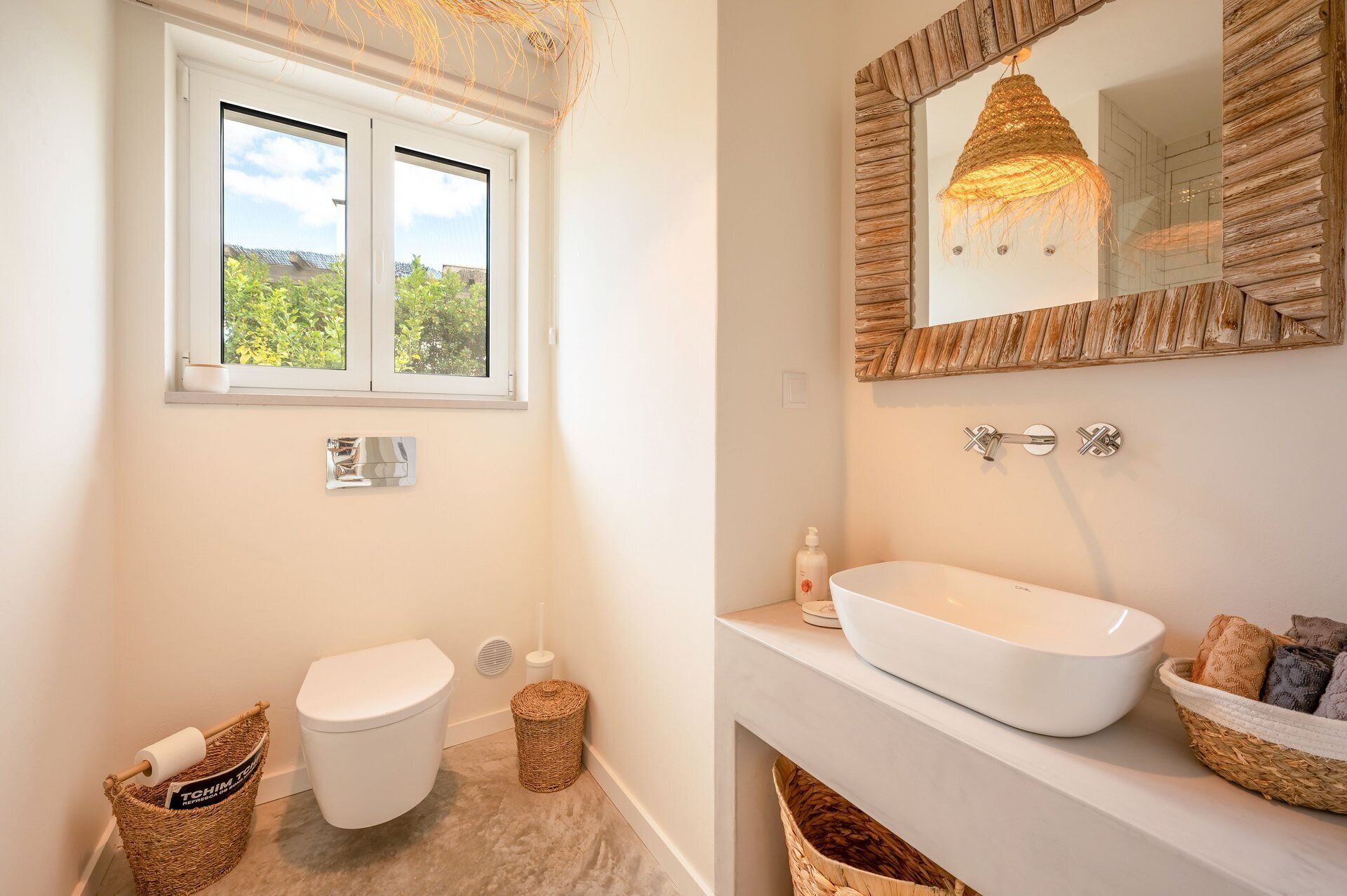 A bathroom with a toilet, bidet, and a large white sink with a mirror above it.