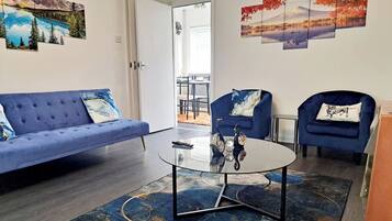 Relax in this stylish living room with a sofa, armchairs, and a coffee table, surrounded by serene views and beautiful artwork.
