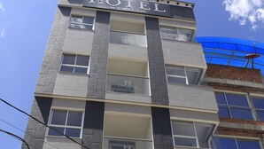 Ett hotell med flera våningar, med en väl synlig skylt som visar texten ”HOTEL OMAGA”.