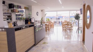 Ett modernt receptionsområde med en disk, hyllor med diverse föremål, en klocka och utsikt mot omgivningen.
