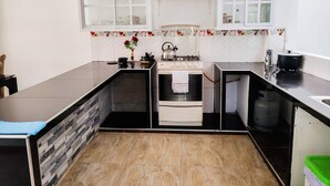 A modern kitchen with a central island, a built-in oven, and a stove. There are cabinets above the counter and a window with a view.
