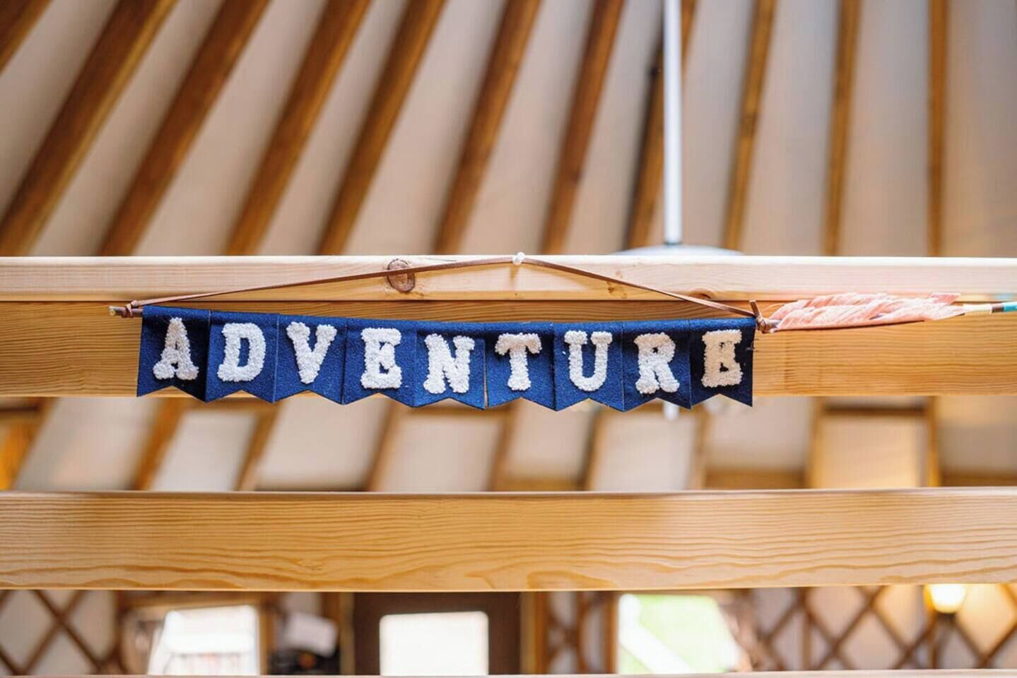 Ein Banner mit dem Wort 'ADVENTURE', das an einer Holzkonstruktion hängt.