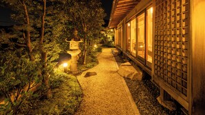 A pathway leading to a traditional building with a tiled entrance and a lantern. - Keyaki no yado En (Koka)