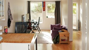 A cozy living room with a wooden dining table, a purple sofa, and a small wooden side table. - Gorgeous apartment with WiFi (Godvik)