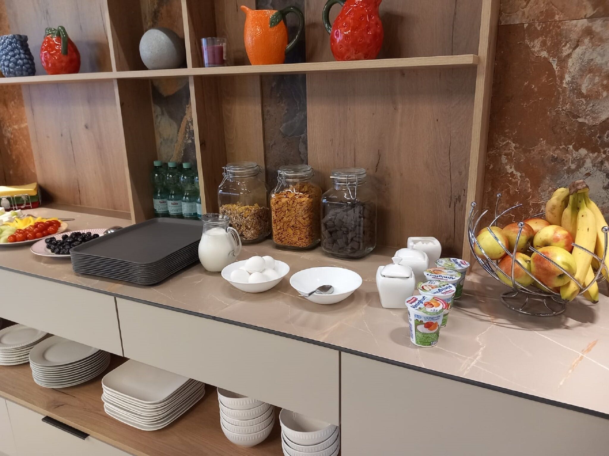 A breakfast buffet setup with various food items and containers.