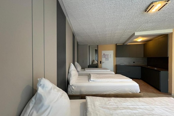 Habitación cuádruple Confort | Edredón, camas Select Comfort y espacio para trabajar con laptop