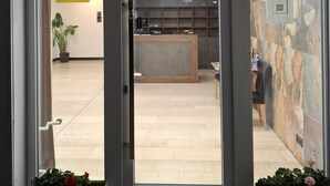 A reception area with a reception desk, a potted plant, and a sign indicating a special event. - Hotel Hafez (Bad Salzuflen)