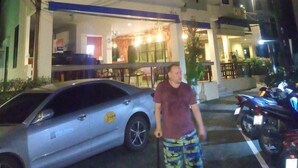 A building with a balcony, a parked car, and a motorcycle. - Royal Waves Hotel (Patong)