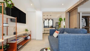Una sala de estar moderna con un sofá azul, una mesa de centro y una estantería.