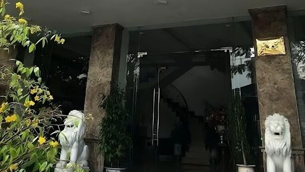 Der Eingang des VIE NEM FRANG Hotels mit einer modernen Fassade, einer Löwenstatue und einem Schild über dem Eingang.