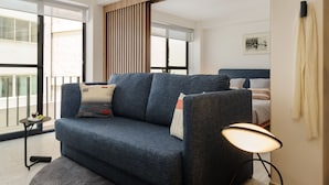 Ein modernes Wohnzimmer mit einer Couch, einem runden Teppich und einer Stehlampe.