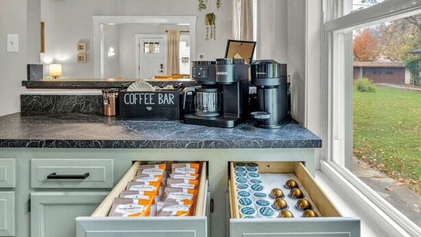 Eine Küche mit einer Kaffeobar, Kaffeemaschinen und einer Schublade voller Kaffeekapseln.