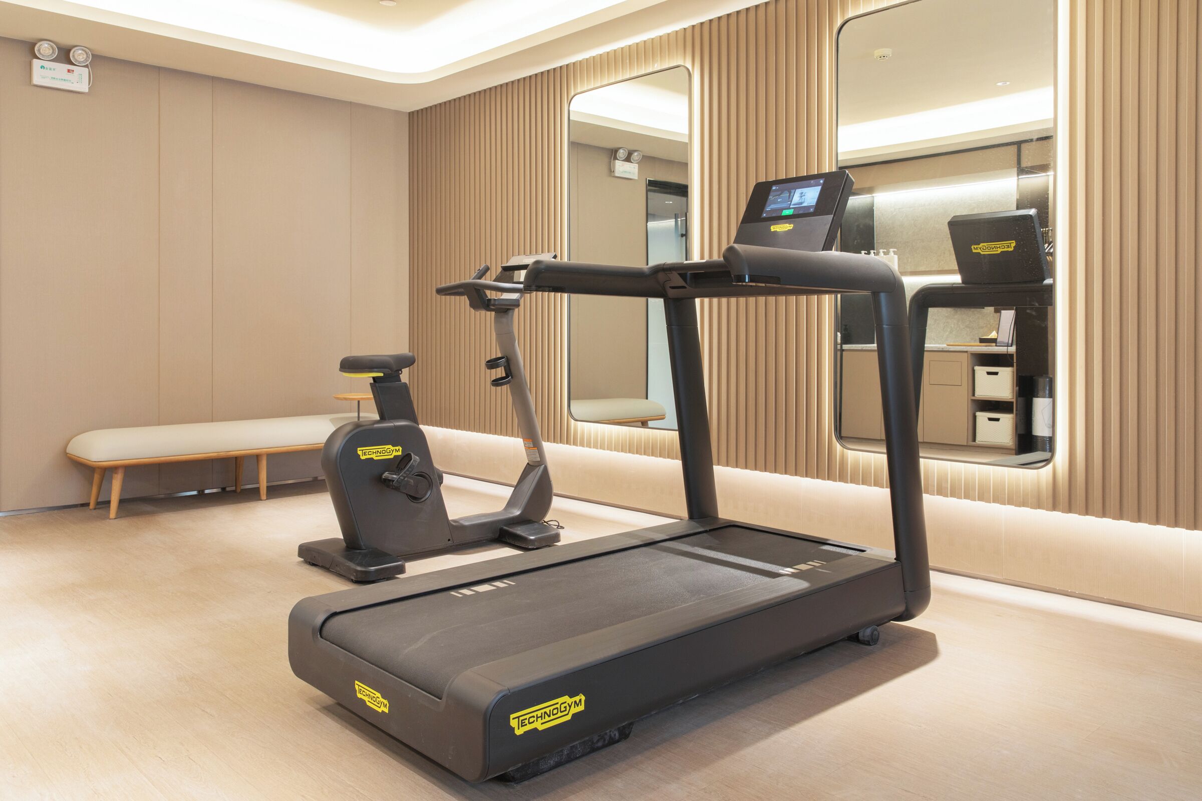 Una palestra moderna con tapis roulant, ellittica e panca.