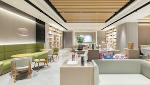 Ein modernes Interieur mit einer Rezeption, einer Sitzecke und Bücherregalen.