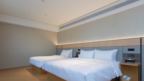 Ein Hotelzimmer mit zwei Betten, einem Nachttisch und einer festen Kopfteil.