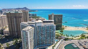 A high-rise hotel with multiple balconies, a beach, and clear blue waters. - Ilikai Hotel Studio (Honolulu)