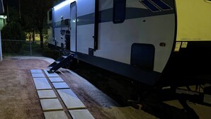 Un camping-car à l’arrêt, avec une plaque d’immatriculation visible et une vue latérale du véhicule.