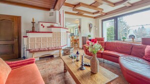 Amplia sala de estar con chimenea, sofás rojos y una mesa de centro de madera.