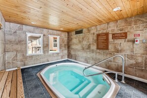 A spa room with a hot tub, wooden ceiling, stone walls, and a tiled floor. - Wild Irishman 1074 - West Keystone - Easy Free Bus to Mountain + Hot Tub, Pool, Sauna (Keystone)