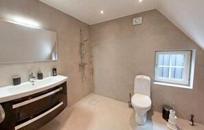 A modern bathroom with a white vanity, a shower, a toilet, and a window. - Lovely home in Sallerup with WiFi (Sallerup)