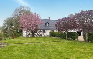 A stone house with a sloped roof and a small attached garage. - Lovely home in Sallerup with WiFi (Sallerup)