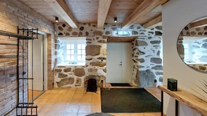 A stone-walled hallway with a wooden ceiling, a door, and a window. - Lovely home in Sallerup with WiFi (Sallerup)