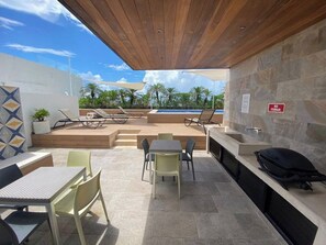 Eine moderne Außenpatio mit Pool, Liegestühlen und Barbereich.
