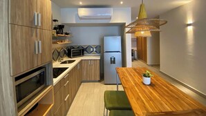 Eine moderne Küche mit Holzschränken, einer Mikrowelle, einem Toaster und einem Kühlschrank.