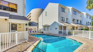 A swimming pool area with a white fence, a pool ladder, and a tiled deck. - Walk to Ocean: Myrtle Beach Townhome w/ Patio (Myrtle Beach)